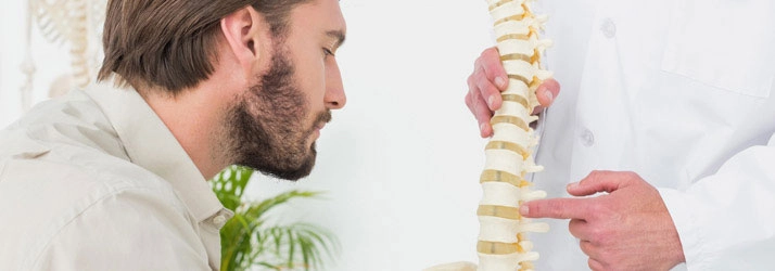 Chiropractic Arlington TX Man Looking At Spinal Disc Model